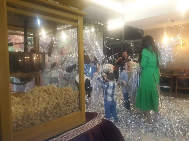 İç mekân etkinliğinde popcorn makinesi ve misafirler