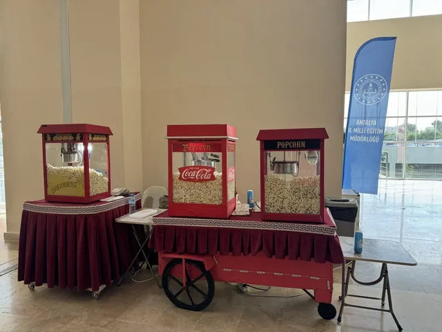 İç mekânda yan yana kurulu üç popcorn makinesi