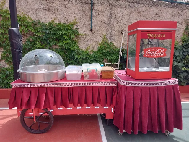 Okul bahçesinde kırmızı araba üzerinde pamuk şeker ve popcorn makineleri