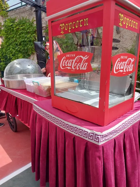 Okul bahçesinde kırmızı araba üzerinde pamuk şeker ve popcorn makineleri