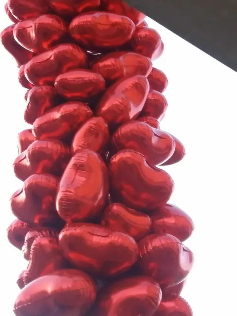 Dikey stant üzerinde kırmızı kalp biçimli balonlar